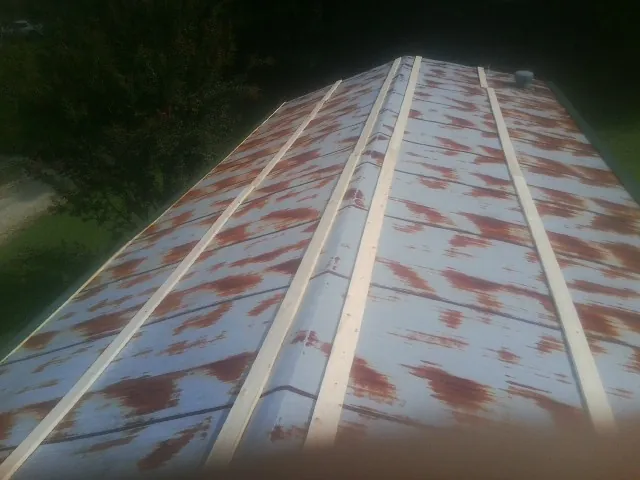 Rusted metal roof panels with new wood purlins before replacement — Storm Damage Roof Repair in Cedar Creek by Roofing Brothers
