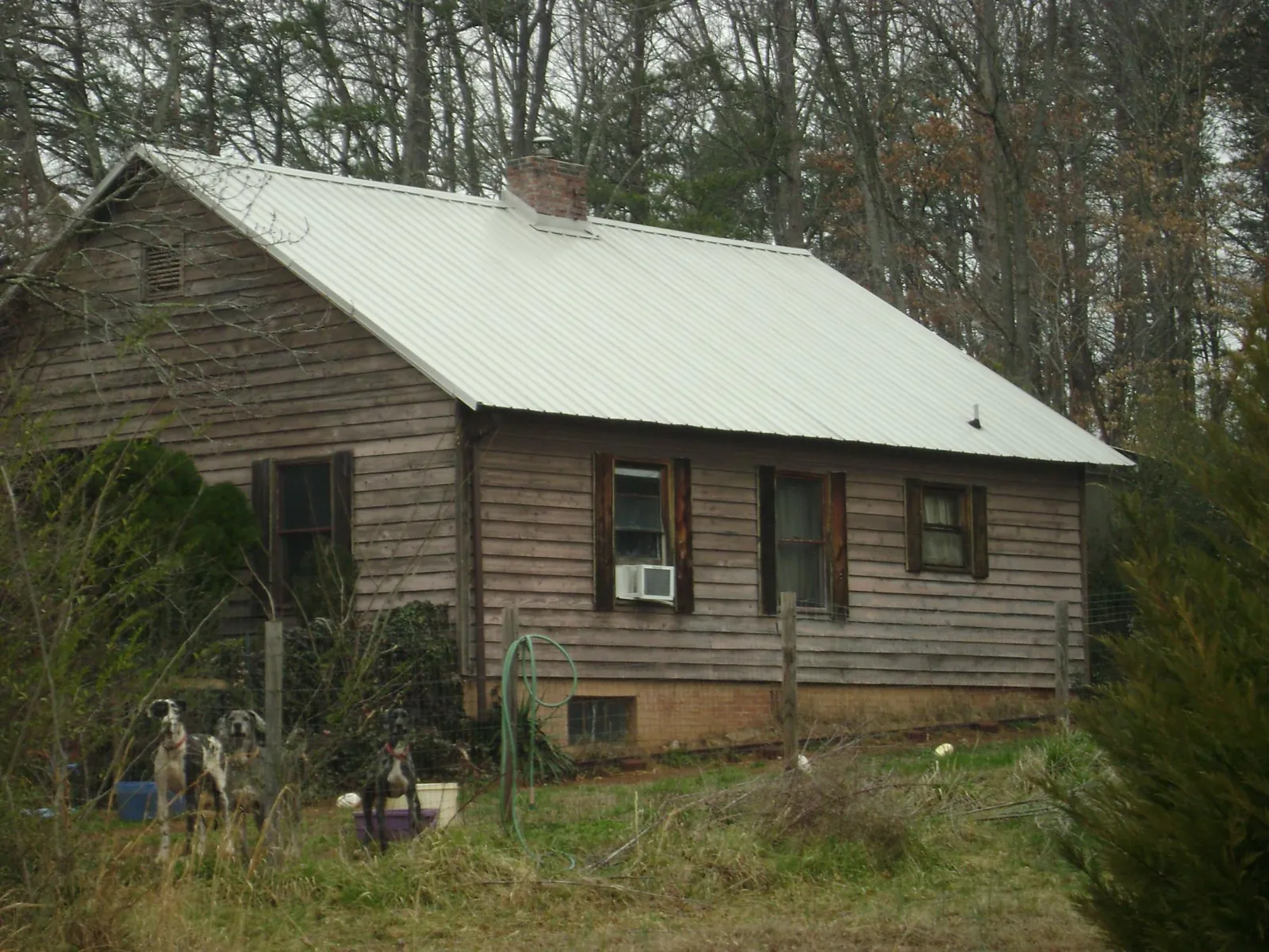 White metal roof on an old wood sided farmhouse, from a Metal Roof Installation job in Cedar Creek